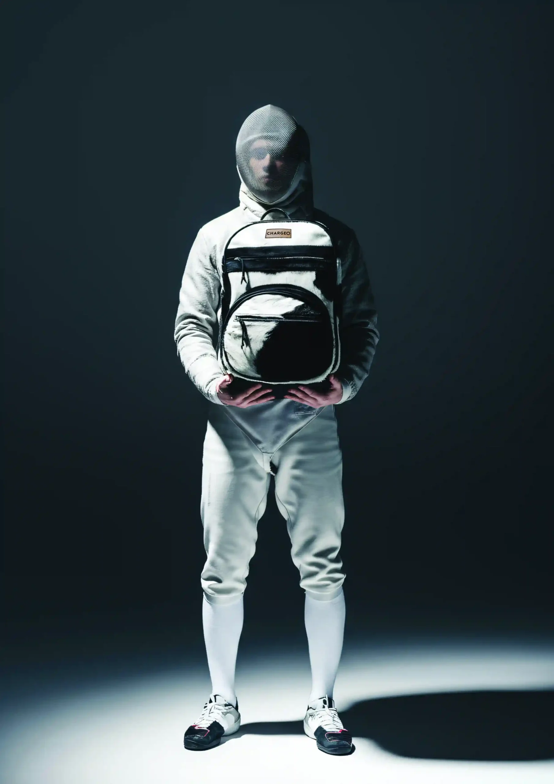 Man in fencing mask holding CHARGEO Zulu Treasure Backpack leather.