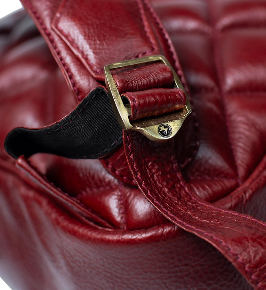 CHARGEO Leather Westville Backpack Ruby Red buckle close up. CHARGEO Leather Westville Backpack Ruby Red buckle close up.