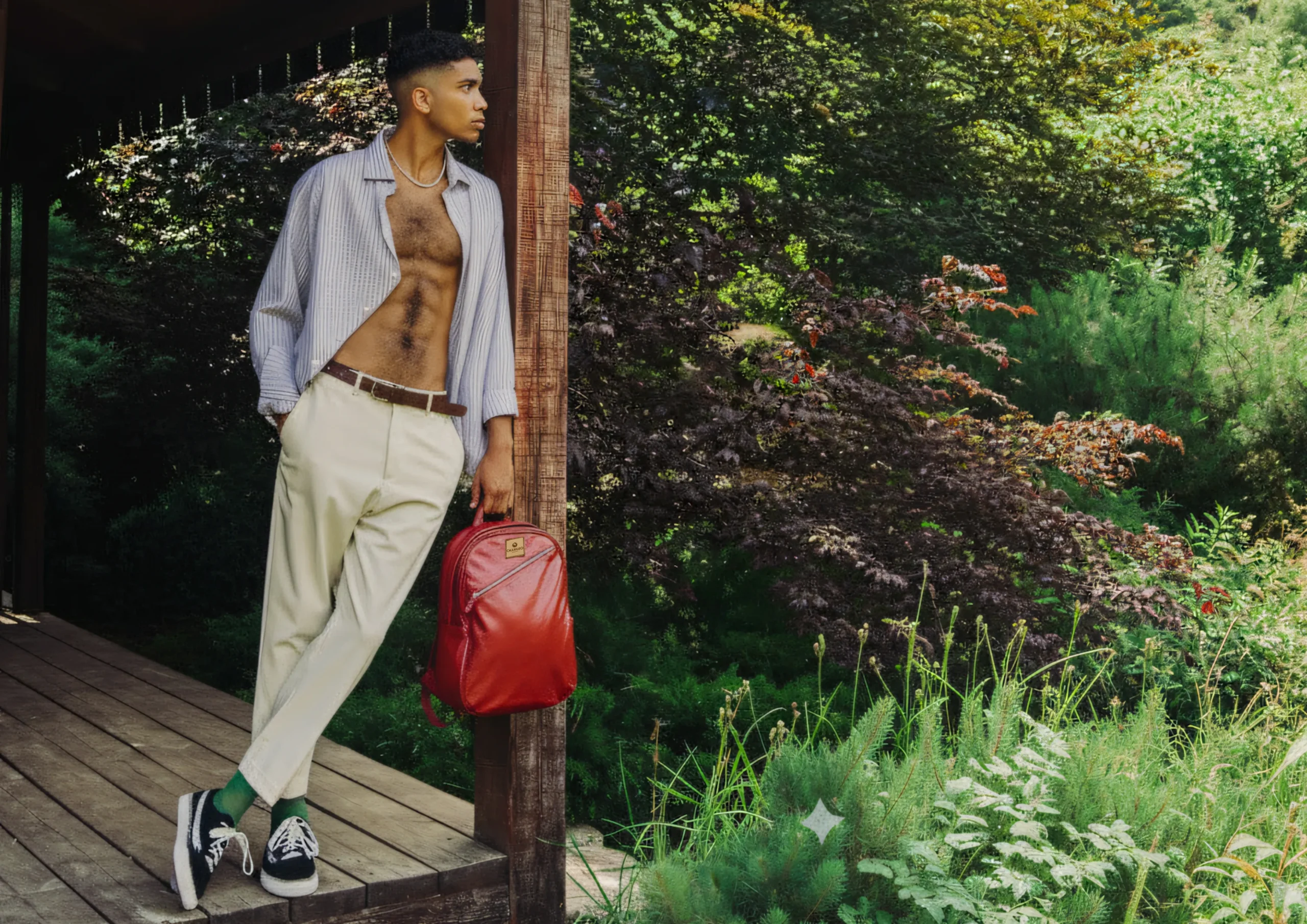 Model standing with CHARGEO Pretoria RedRuby leather backpack held by the side