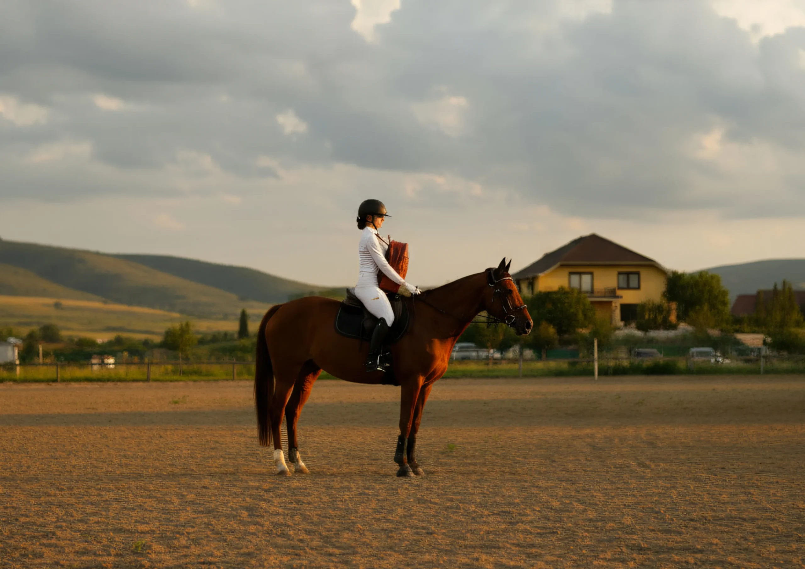 Side view of a woman on horseback with a CHARGEO Stellenbosch Backpack in Cognac leather