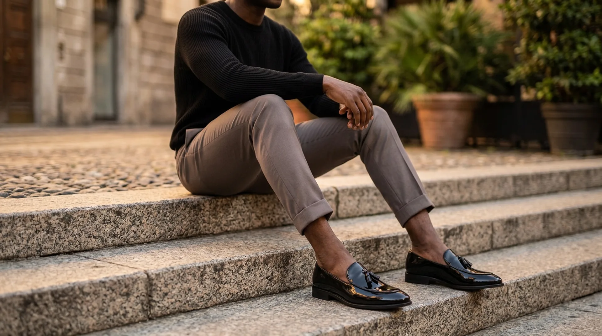 Man seated on steps wearing a black jumper and CHARGEO loafers