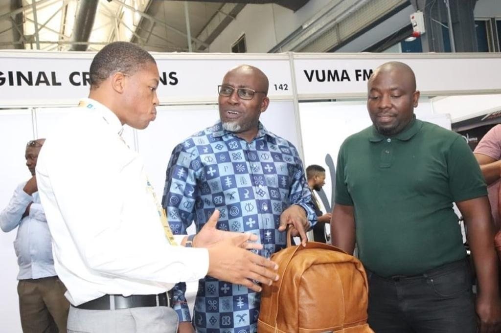 Terrence Fumba shows a CHARGEO tan leather backpack to the then Mayor of eThekwini, Mxolisi Kaunda, at the Durban Business Fair, 2022